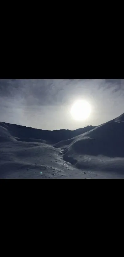 Snowy mountains under cloudy sky with sun shining.