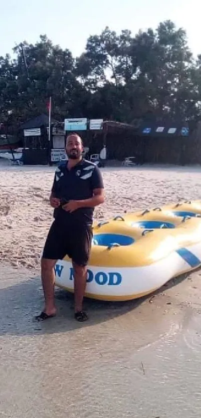 A person with a yellow inflatable raft on a sunny beach.