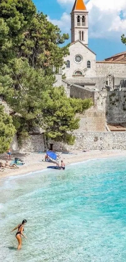 Scenic beach with turquoise waters and historic church view.