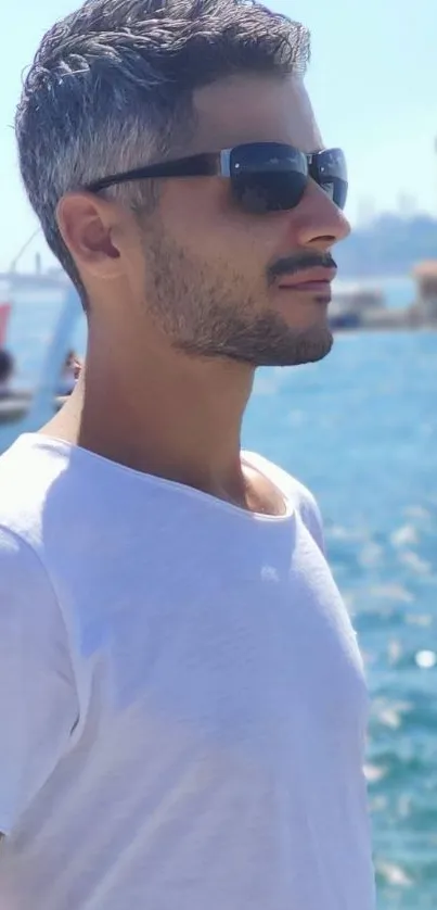 Man in sunglasses with ocean backdrop, sunny day.