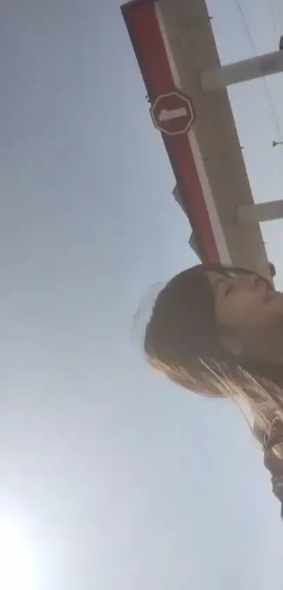 Woman at gas station with sunny sky.