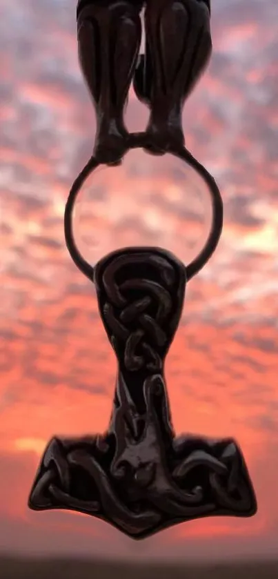 Pendant silhouette against sunset sky with orange hues.