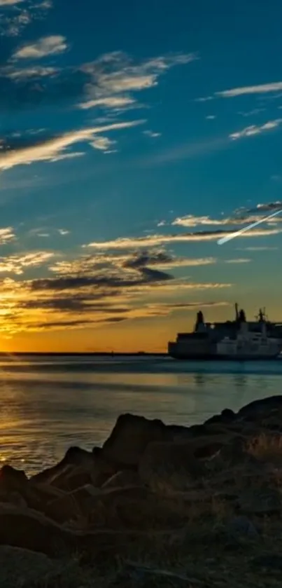 Sunset over ocean with silhouetted ship and vibrant sky.