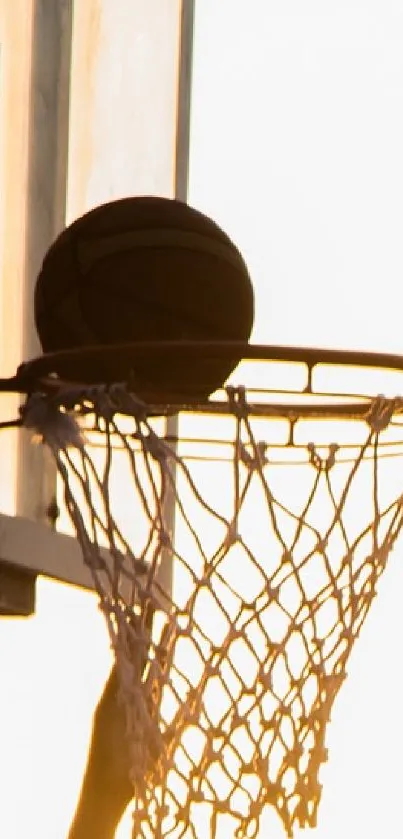 Silhouette of a basketball player making a shot at sunset.