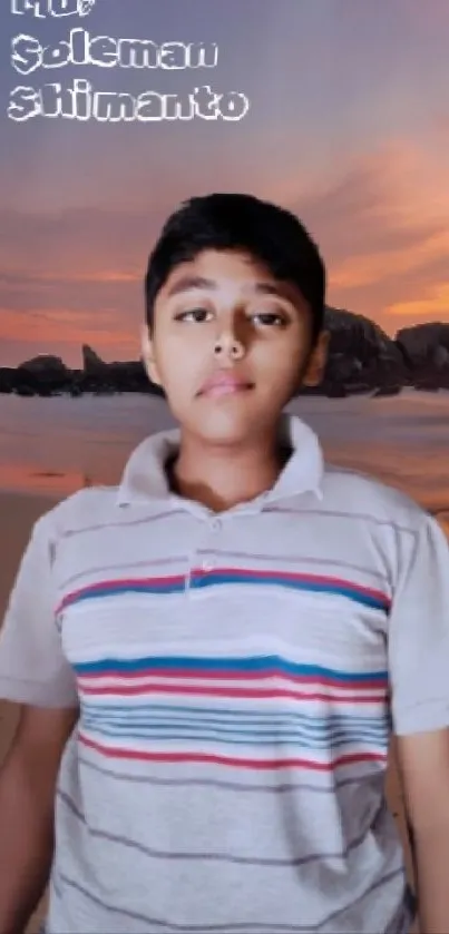 Young boy posing at a sunset beach scene with rocks and ocean waves.