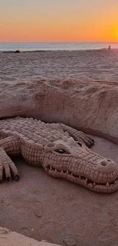 Sand crocodile sculpture on the beach at sunset.