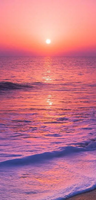 Serene sunset view over a pink-hued ocean at the beach.