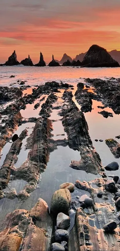 Beautiful sunset over rocky beach with serene ocean view.