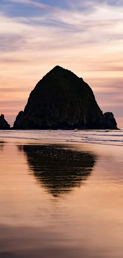 Haystack Rock sunset reflecting on serene beach.