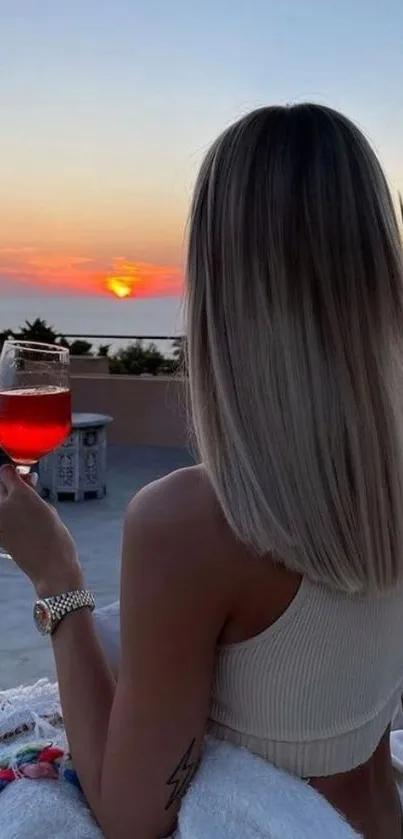 Woman enjoying sunset beach view with a drink, perfect for mobile wallpaper.