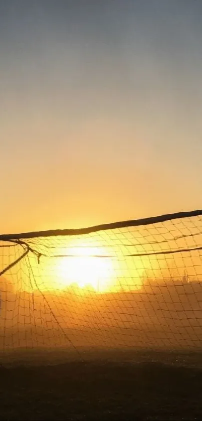 Soccer goal silhouette at sunset with golden glow.