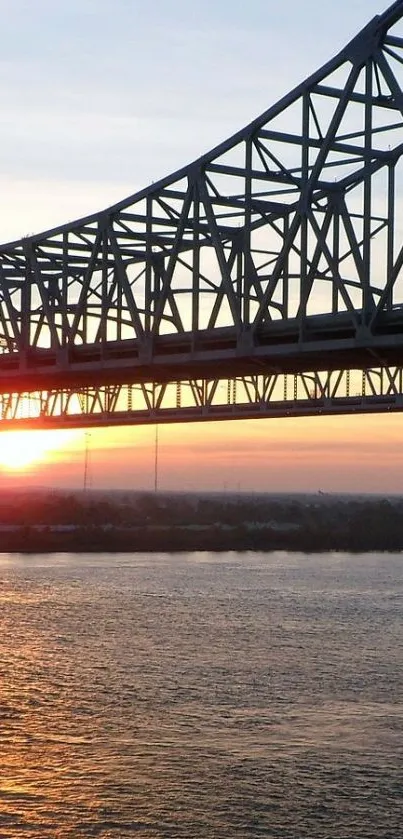 Sunset behind a bridge over a calm river, creating a serene silhouette.