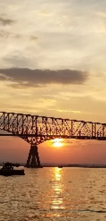 Panoramic sunset with bridge over calm water reflecting vibrant skies.