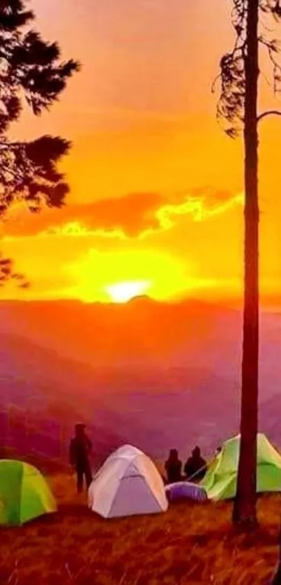 Sunset over a campsite with glowing tents and trees.