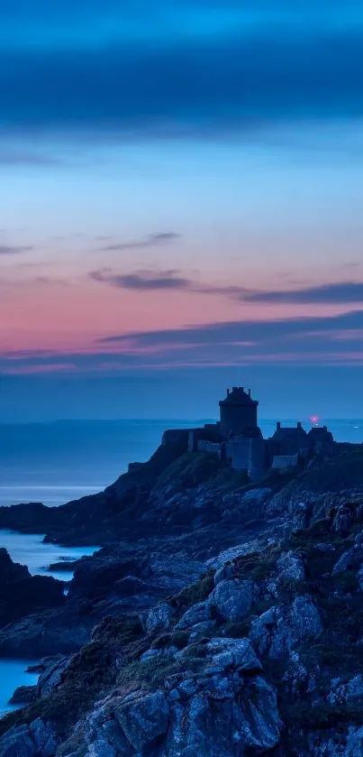 Castle overlooking ocean at blue sunset.