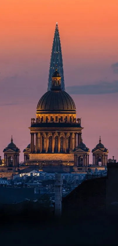 Stunning sunset cityscape with illuminated architecture and vibrant orange sky.