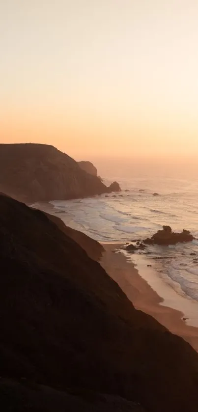 Sunset over ocean with coastal cliffs in view.