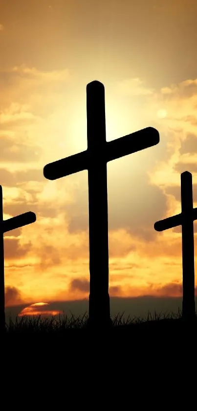 Three silhouetted crosses against a vibrant orange sunset sky.