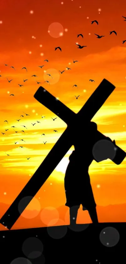 Silhouette of a cross against an orange sunset with birds flying.