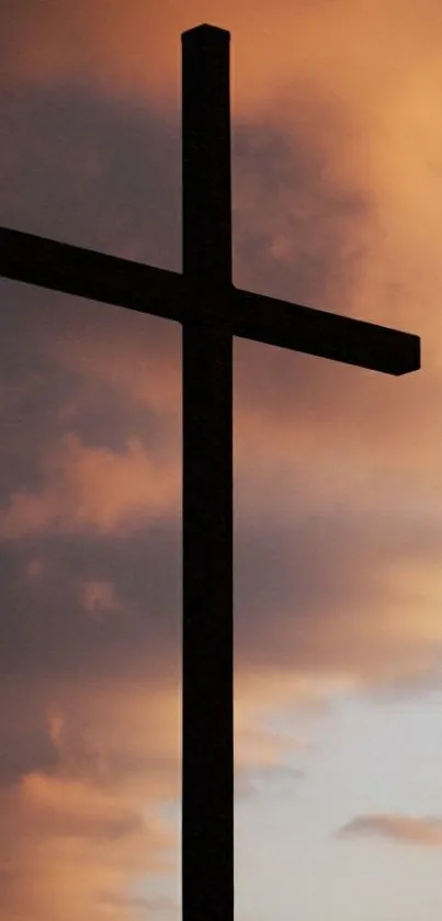 Silhouette of a cross against an orange sunset sky.