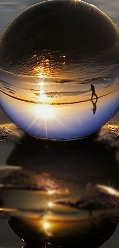 Crystal ball reflects a serene sunset on the beach, perfect for mobile wallpaper.