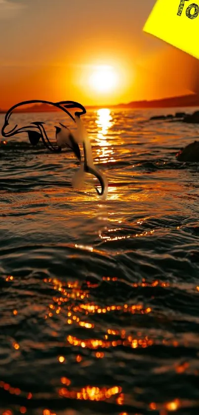 Dolphin silhouette against a vibrant sunset over the ocean.