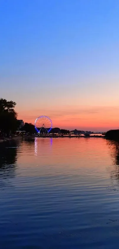 Beautiful sunset over river with Ferris wheel reflection and vibrant sky.