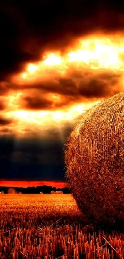 Dramatic sunset over a field with hay bales, capturing vibrant colors.