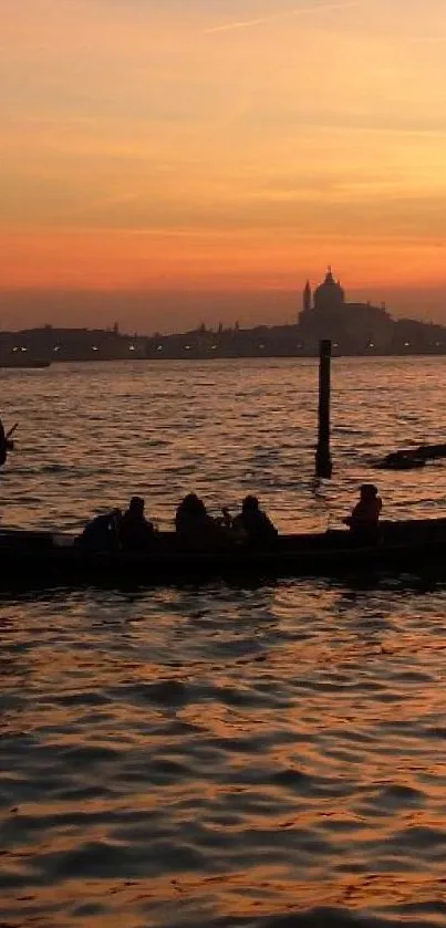 Silhouetted gondola on water during a vibrant orange sunset.