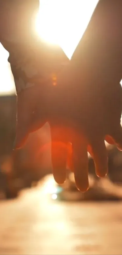 Two hands holding in warm sunset glow.