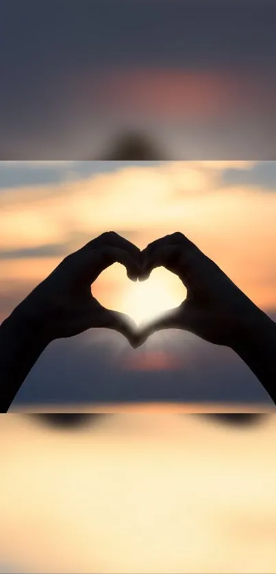 Hands forming a heart at sunset with an orangish sky backdrop.