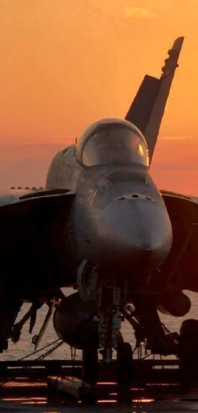 Jet fighter against an orange sunset, highlighting its silhouette on a carrier.