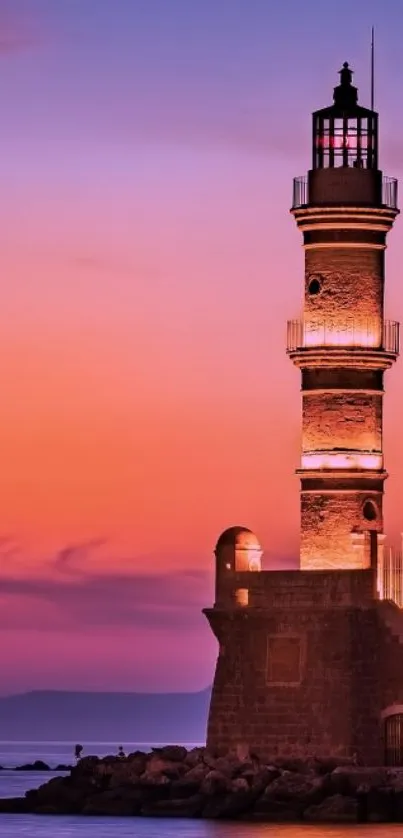 Lighthouse at sunset with orange and purple sky.