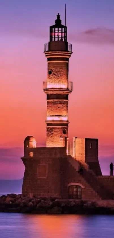 Lighthouse at sunset with vibrant sky hues reflecting over the ocean.