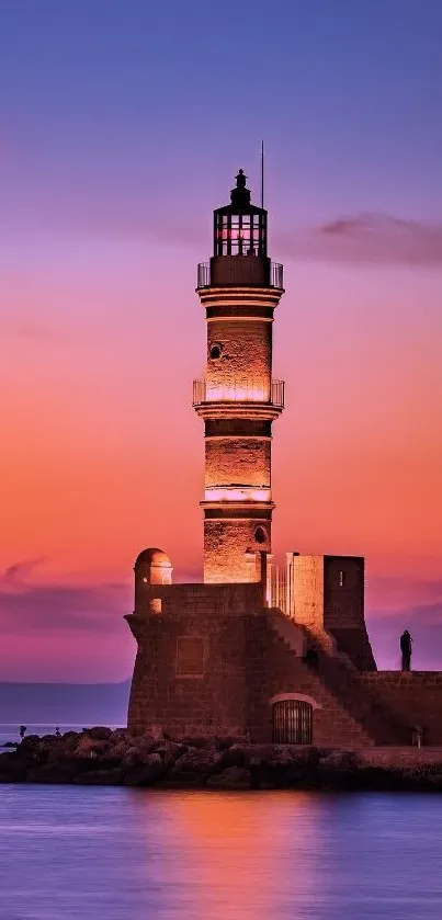 Lighthouse by the sea during a vibrant sunset with orange and purple hues.