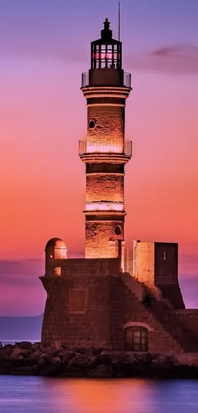 Beautiful lighthouse at sunset over calm sea with vibrant sky colors.