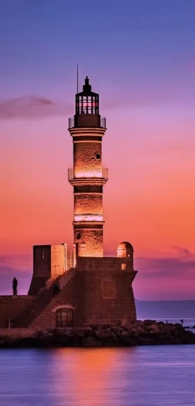 Lighthouse during vibrant sunset over calm ocean waters.