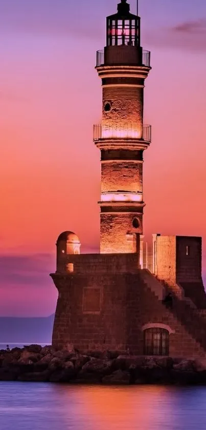 Lighthouse at sunset with vibrant orange sky and calm sea.