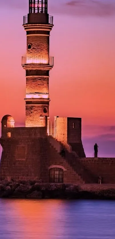 Lighthouse at sunset with vibrant orange and purple hues over a calm sea.