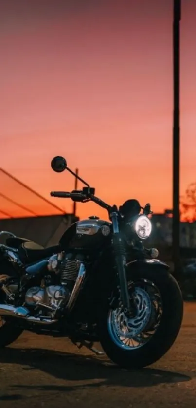 Motorcycle parked at sunset under a vibrant orange sky.