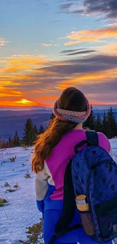 Scenic sunset view over snowy mountains with backpacker.