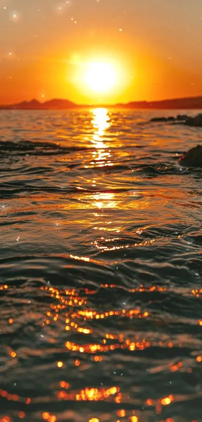 Stunning sunset over ocean with orange sky and glowing water reflections.