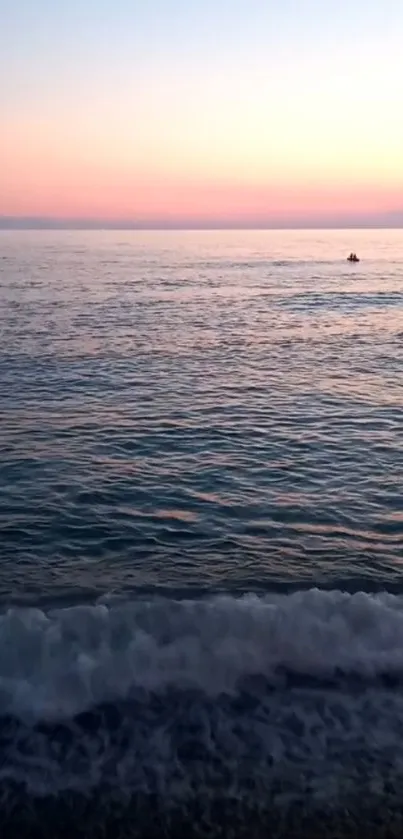 Serene sunset over ocean with waves and a colorful gradient sky.