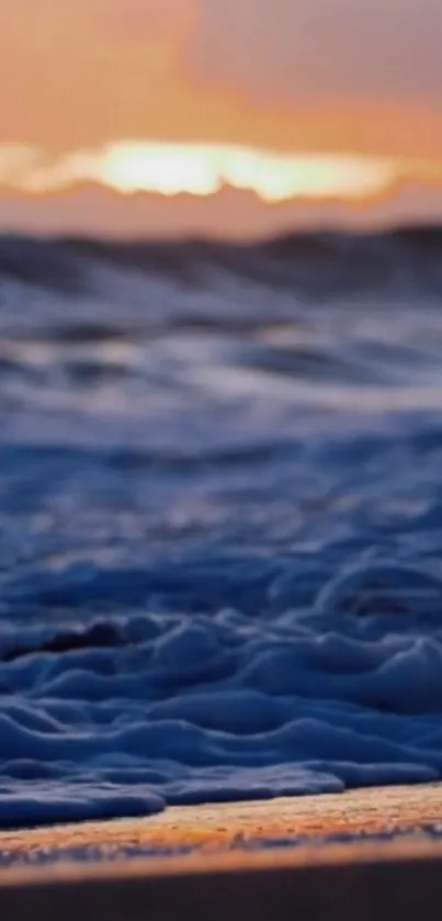 Sunset over ocean waves with a golden sky.