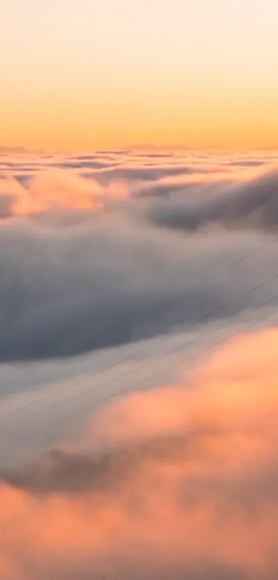 Sunset over a sea of clouds with vibrant peach hues.