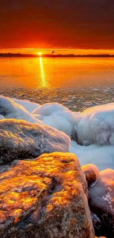 Orange sunset over icy rocks reflecting on a frozen lake.