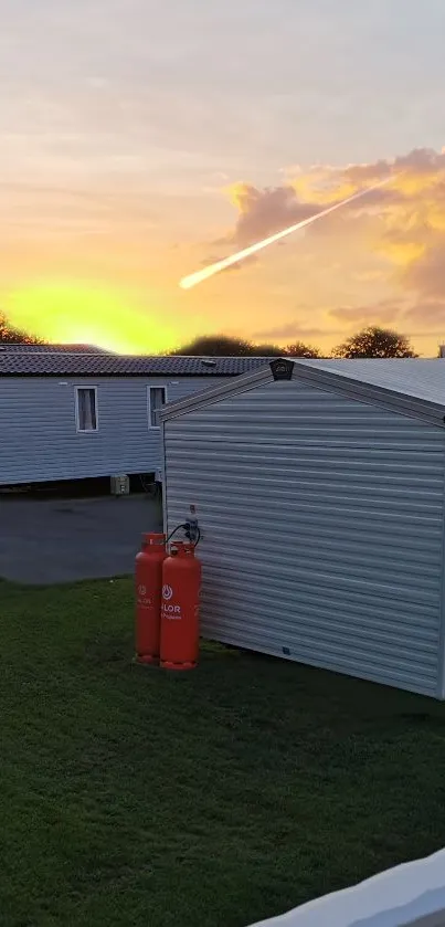 Sunset over mobile homes with vibrant sky and peaceful atmosphere.