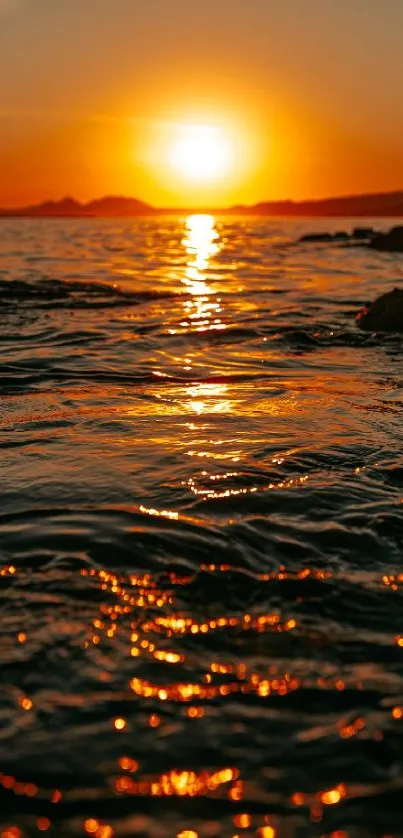 Vivid sunset over ocean waves with orange and gold reflections.