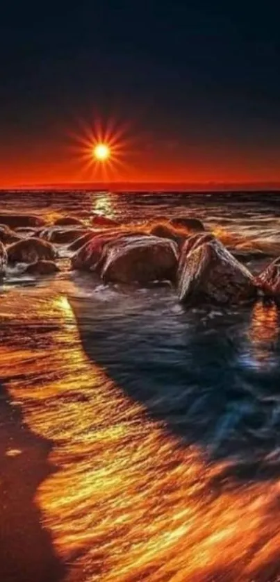 Beautiful sunset over rocks at beach with vibrant orange hues.