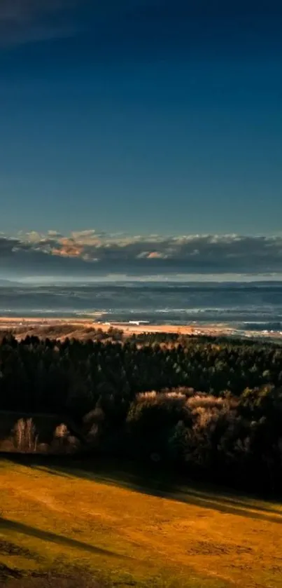 Beautiful sunset over a scenic landscape with lush fields and a dark blue sky.